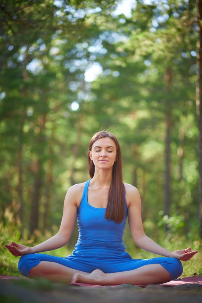 Young woman sitting outdoors in yoga position