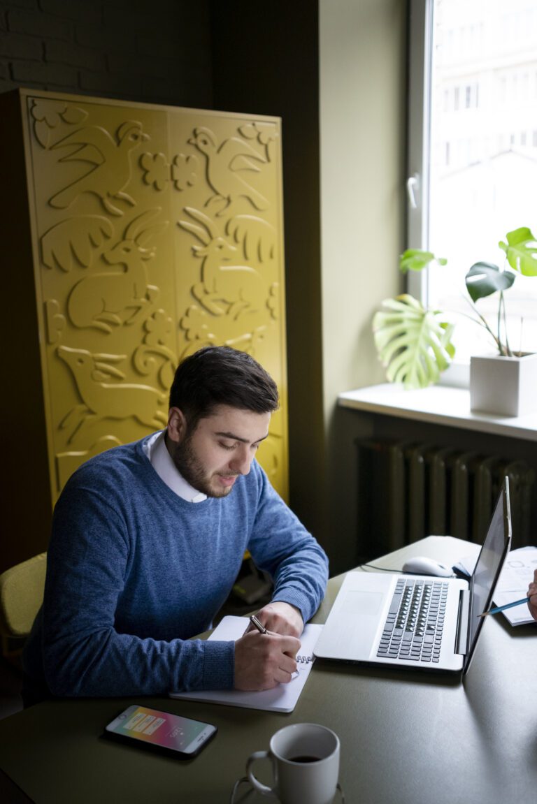 man-sitting-at-computer-writing